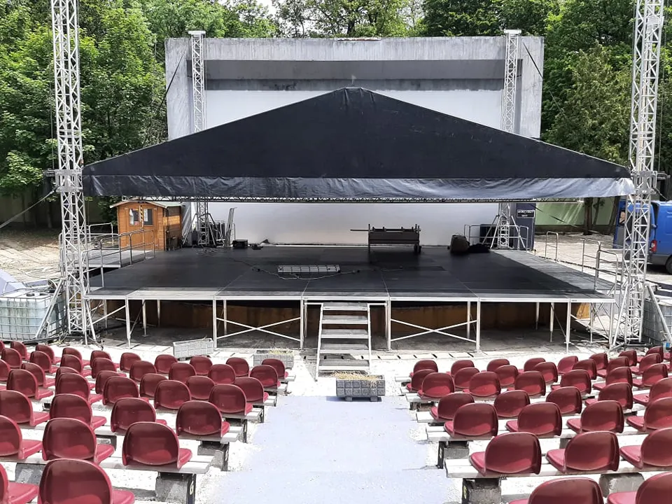 Tomkostage TS3 12x10 mobilszínpad | 100cm-140cm láb | szoknya | oldalra és sarokra korlát |  2x négyfokos önszintező lépcső és 4x lépcsőkorlát | szállítókocsi és hordláda